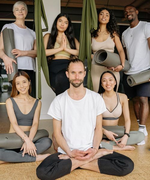 Diverse group of people smiling during a yoga class.